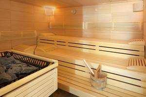 Innenansicht der Sauna im Hipotels Cala Millor Park Hotel mit Holzbänken und Fässern.