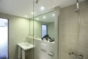 Badezimmer des Playa Golf Hotel mit Glasdusche, Waschbecken und Spiegel