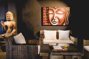 Buddha-Statue in der Hotellobby des Playa Golf Hotels mit gerahmtem Porträt