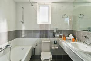 Badezimmer im Kipriotis Village Resort mit Badewanne, Toilette und Waschbecken.