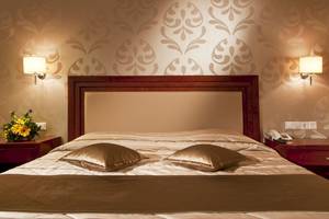 Hotelzimmer im Kipriotis Village Resort mit Doppelbett, zwei Kissen und Nachttischen.