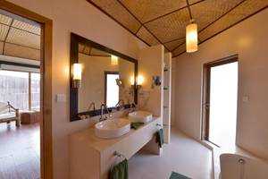 Ein Badezimmer des Safari Island Resorts mit zwei Waschbecken, einem Spiegel und einer Badewanne.