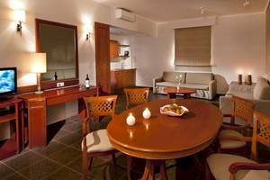 Innenbereich des Kipriotis Village Resort mit Esstisch, Stühlen, Sofa, Fernseher und Dekorationsgegenständen.