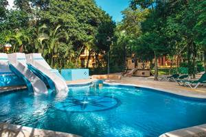 Pool des Riu Lupita Hotels mit Rutschen und Liegen vor tropischer Kulisse