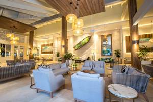 Lobby des Vista Sol Punta Cana Beach Resort & Spa mit modernen Möbeln und hängenden Lampen.