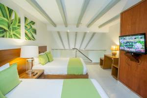 Doppelzimmer im Vista Sol Punta Cana Beach Resort & Spa mit zwei Betten, Fernseher und Lampen.