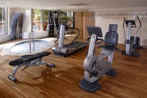 Fitnessbereich im Aquila Porto Rethymno Hotel mit Whirlpool, Laufband und anderen Geräten.