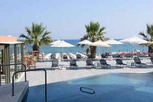 Außenpool und Liegestühle am Strand des Aquila Porto Rethymno Hotels