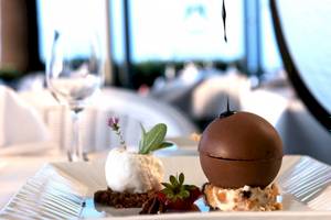 Dessert auf einem Tisch im Aquila Porto Rethymno Hotel mit Eiscreme und Schokoladenverzierung.