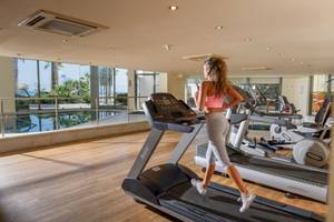 Eine Frau läuft auf einem Laufband im Fitnesscenter des Aquila Porto Rethymno Hotels.