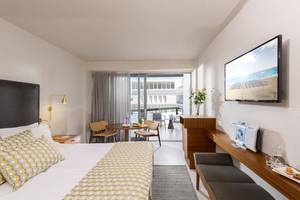 Innenansicht eines modernen Hotelzimmers von Aquila Porto Rethymno mit Blick auf die Terrasse und das Meer.