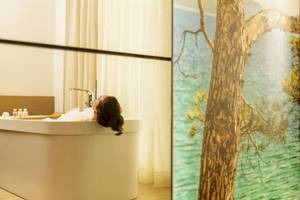 Eine Frau genießt ein Bad in einer Badewanne im Pure Salt Garonda Hotel.