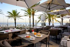 Terrasse des Pure Salt Garonda Hotels mit Blick auf das Meer und Palmen
