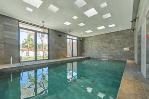 Innenpool des Pure Salt Garonda Hotels mit grünem Wasser und modernen Fliesen.