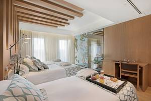 Doppelzimmer im Pure Salt Garonda Hotel mit zwei Betten, Frühstückstablett und Schreibtisch