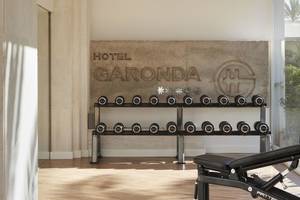 Fitnessbereich im Pure Salt Garonda Hotel mit Gewichtsbank und Hanteln.
