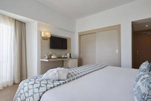 Hotelzimmer von Pure Salt Garonda mit einem Bett, Fernseher, Nachttisch und Badezimmertür.