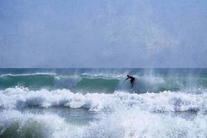 Surfer im Meer, der eine Welle reitet