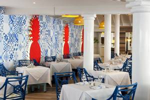 Innenbereich des Restaurants im Gran Ventana Beach Resort mit blauen Stühlen und Tischen.