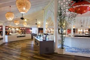 Innenansicht des Gran Ventana Beach Resorts mit Holzboden, bunten Wandfliesen und rustikalen Leuchten.