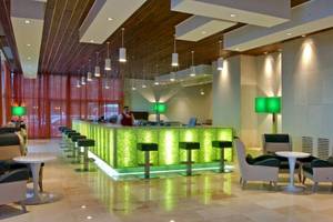 Lobby des Atlantica Nissaki Beach Hotels mit grüner Theke und modernen Möbeln.