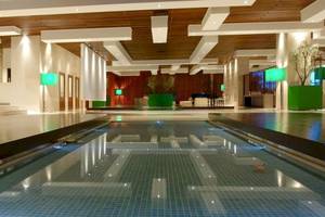Innenpool des Atlantica Nissaki Beach Hotels mit modernen Leuchten und blauen Fliesen.