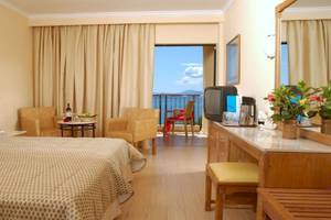 Hotelzimmer im Atlantica Nissaki Beach Hotel mit Blick auf das Meer und Balkon.