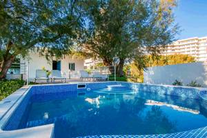 Außenpoolbereich des Pegasos Deluxe Beach Hotels mit Lounge-Stühlen und Bäumen.