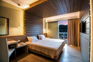 Doppelzimmer im Pegasos Deluxe Beach Hotel mit zwei Betten, Schreibtisch und Balkon.