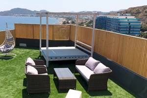 Dachterrasse des Pegasos Deluxe Beach Hotels mit Blick auf das Meer und moderne Gebäude.