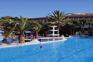 Außenpool des Kipriotis Hippocrates Hotels mit Palmen und Sonnenschirmen