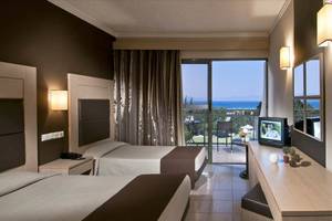 Zwei Betten in einem Hotelzimmer des Kipriotis Hippocrates mit Blick auf das Meer.