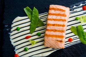 Gegrillter Lachs auf schwarzem Teller mit Gemüse
