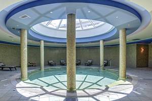 Wellnessbereich im Atlantica Marmari Palace mit Pool und Liegen