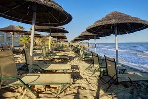 Strand des Atlantica Marmari Palace mit vielen Liegen und Sonnenschirmen