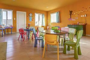 Kinderspielzimmer im Atlantica Marmari Palace mit bunten Tischen und Stühlen.