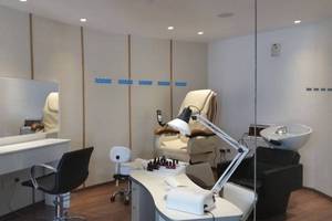 Schönheitssalon im Cavo Maris Beach Hotel mit mehreren Behandlungsräumen und Möbeln.
