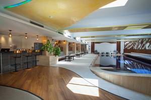 Innenbereich des Cavo Maris Beach Hotels mit Bar, Möbeln und Swimmingpool.