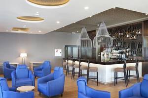 Innenansicht des Bar- und Loungebereichs des Playa Vista Azul Varadero Hotels mit blauen Sesseln, einer Theke und Kronleuchtern.