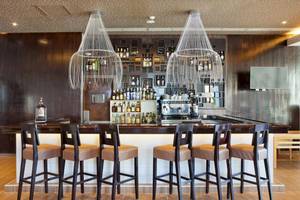 Innenansicht der Bar im Playa Vista Azul Varadero Hotel mit Barhockern, Flaschen und zwei großen Kronleuchtern.