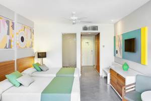 Doppelbett-Zimmer im Playa Vista Azul Hotel in Varadero mit bunten Wandbildern und moderner Einrichtung.