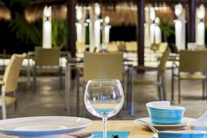 Abendessen im Cocoon Maldives Hotel Restaurant mit gedeckten Tischen und Stühlen.