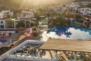 Luftaufnahme des Fuerteventura Princess Hotels mit Swimmingpool und Sonnenuntergang im Hintergrund.