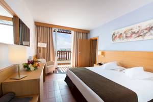 Innenansicht eines Hotelzimmers im Fuerteventura Princess mit einem Bett, einem Balkon und einer modernen Einrichtung.