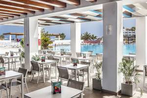 Restaurantbereich mit Tischen und Stühlen neben einem Swimmingpool im Fuerteventura Princess Hotel.