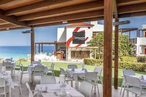Außenbereich des Fuerteventura Princess Hotels mit Tischen und Stühlen, Blick auf das Meer.