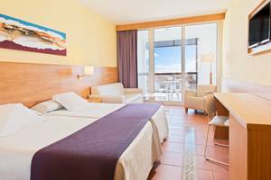 Doppelzimmer im Fuerteventura Princess Hotel mit zwei Betten, Blick auf die Terrasse und Möbeln.