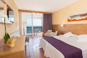 Hotelzimmer im Fuerteventura Princess mit Meerblick, Bett, Schreibtisch und Balkon.