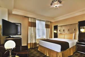 Hotelzimmer im New Yorker mit Fernseher, Bett und Nachttisch