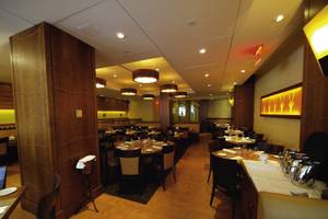 Innenansicht des New Yorker Restaurants mit geräumigen Tischen, Holzelementen und warmem Licht.